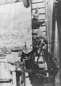 Vertov bei Aufnahmearbeiten auf einer Leiter stehend