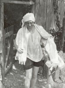 Dziga Vertov mit Turban, Handtuch und weißer Hose in der Hand