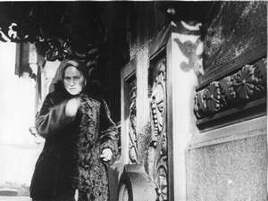 Alte Frau an der Kirche