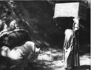 Frau mit Kiste auf dem Kopf