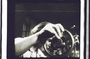 Frau an der Nähmaschine, Hand am Rad