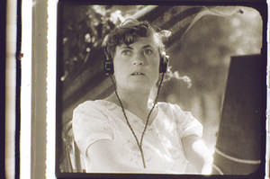 Frau mit Kopfhörer, frontal, schaut nach oben