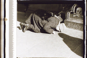 Frau liegt vor dem Kreuz