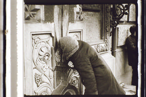 Frau küsst das Kreuz