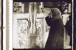 Frau bekreuzigt sich vor dem Kreuz