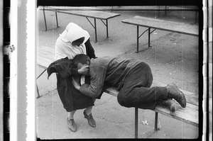 Betrunkener schläft auf Bank, Frau dabei